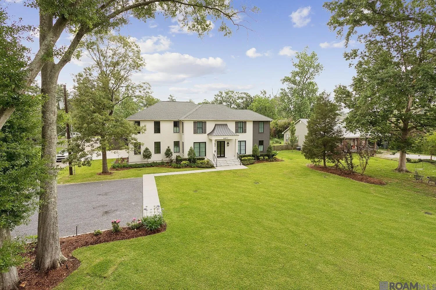 Rear lawn, house, and mature trees