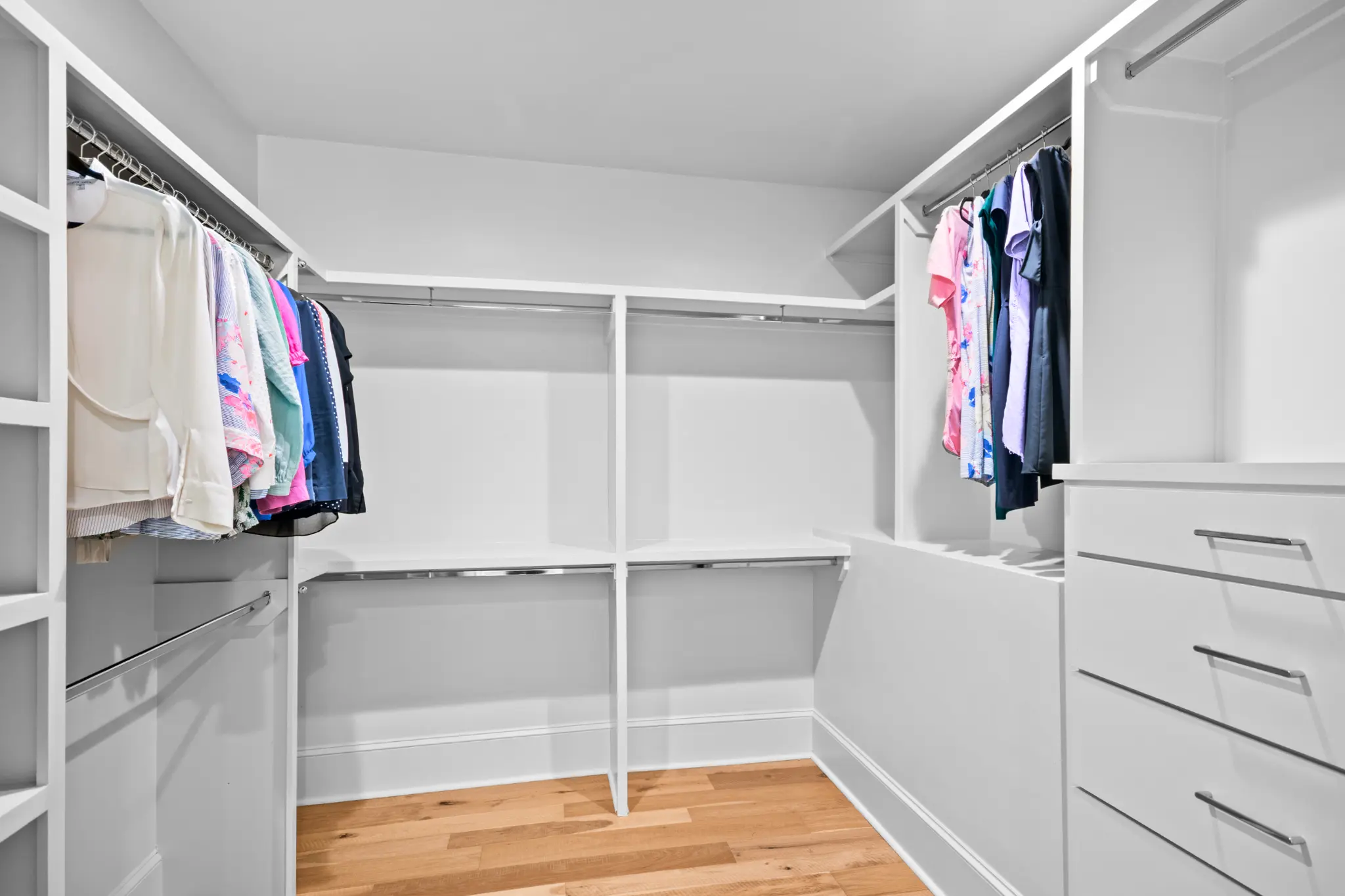 His-and-hers primary suite closet with built-in cabinetry